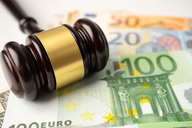 Imagen de un mazo de juez con dinero debajo.