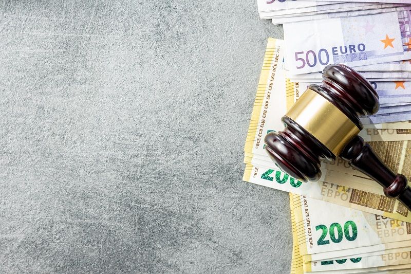 Imagen de un mazo de juez con dinero debajo.