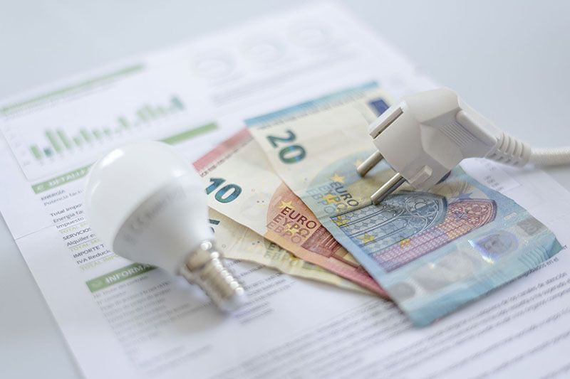 Imagen de un enchufe, una bombilla, dinero y debajo una factura de energía. Imagen que hace referencia a las reclamaciones.