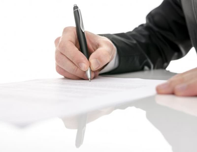 Una persona firmando un contrato.