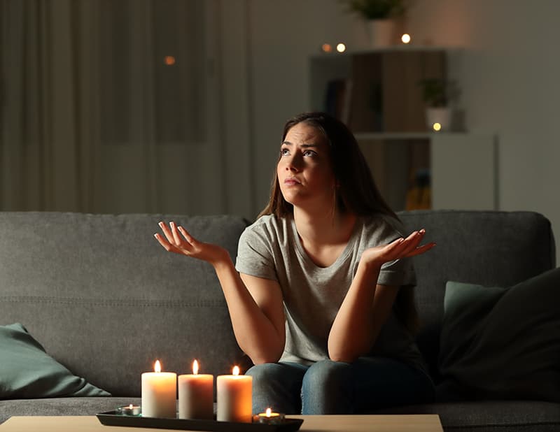 Una chica que se ha quedado sin luz y tiene velas encendidas. Reclamaciones de daños por cortes.