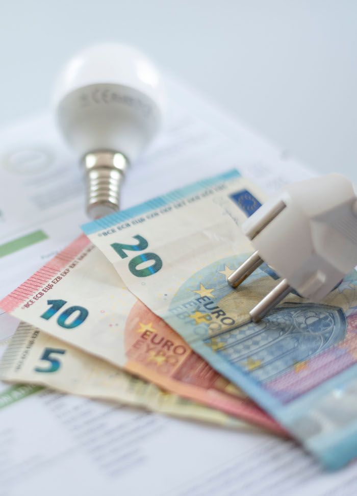 Imagen de un enchufe, una bombilla, dinero y debajo una factura de energía. Imagen que hace referencia a las reclamaciones.